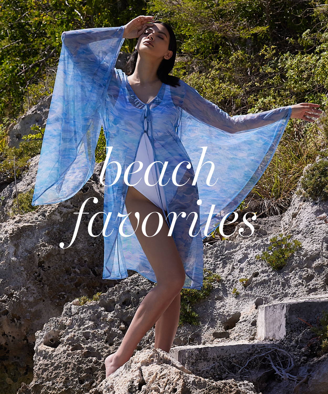 Beach Favorites | Woman wearing ocean wave blue printed mesh duster over white bathing suit by the water by Ala von Auersperg for summer 2023