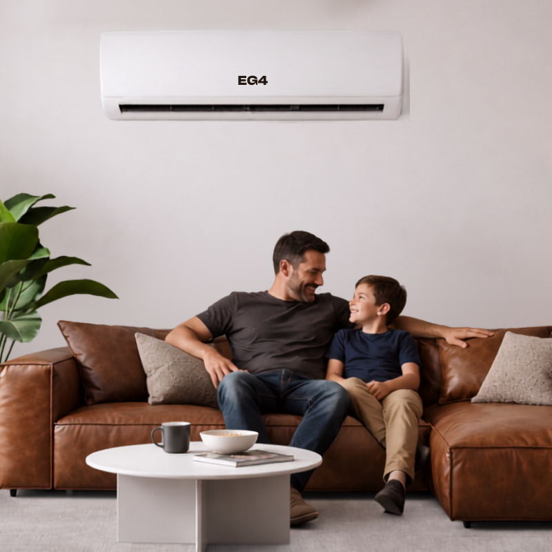 A father and son sitting together on a couch with an EG4 mini split unit above.