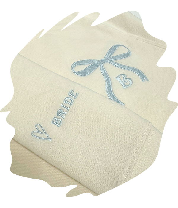 Close-up of beige garment with embroidered ribbon graphic and 