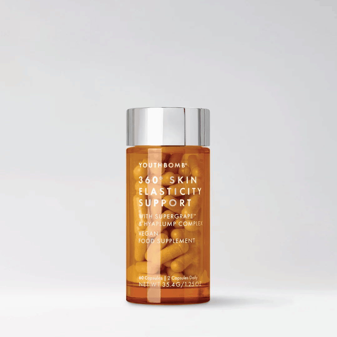 Bottle of skin supplement with a silver cap on a plain background.