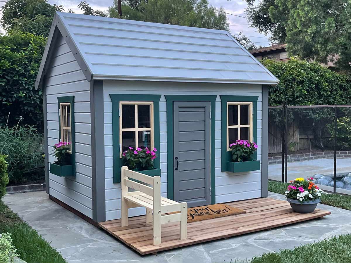 Blue Wooden Playhouse with gray door, green flower boxes and a wooden terrace by WholeWoodPlayhouses
