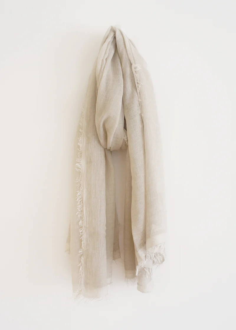 An off white bamboo scarf with raw hem detailing