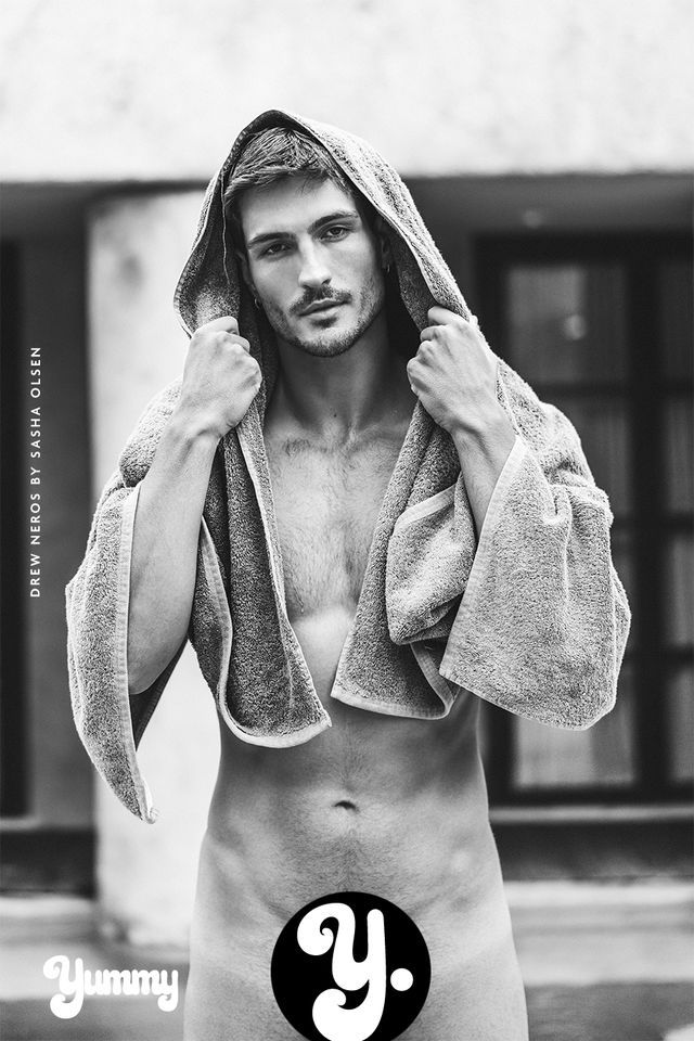 Black and white photo of a man wearing a towel, partially nude.