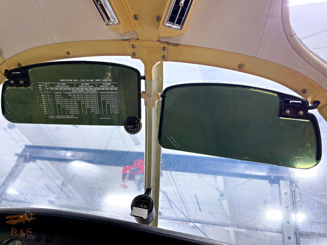 Cockpit view showing green sun visors and overhead panel.