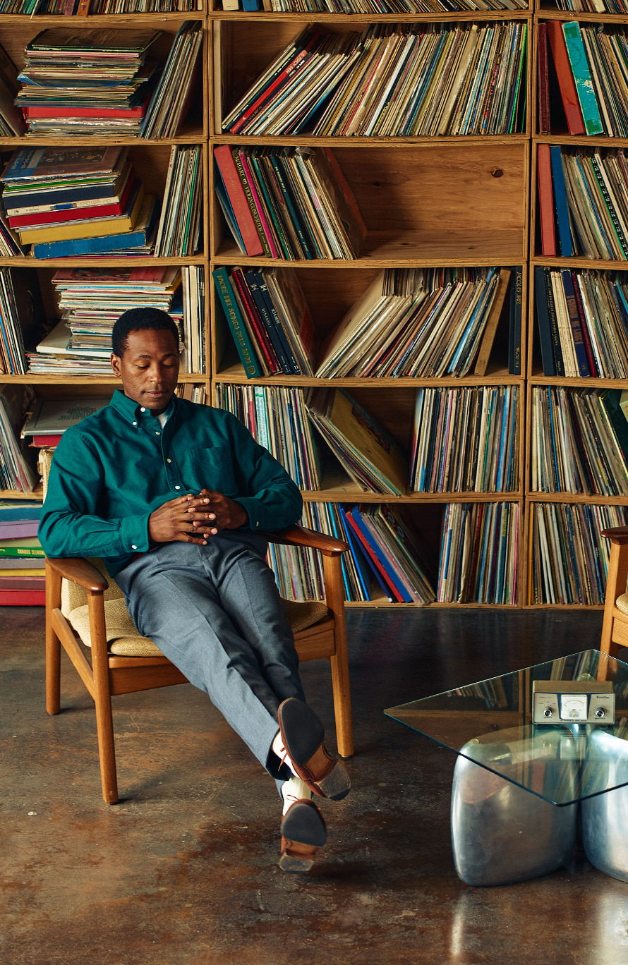 A person sitting in a chair, surrounded by vinyl records.