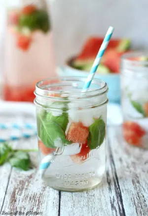 Glass with water and watermelon and basil leaves