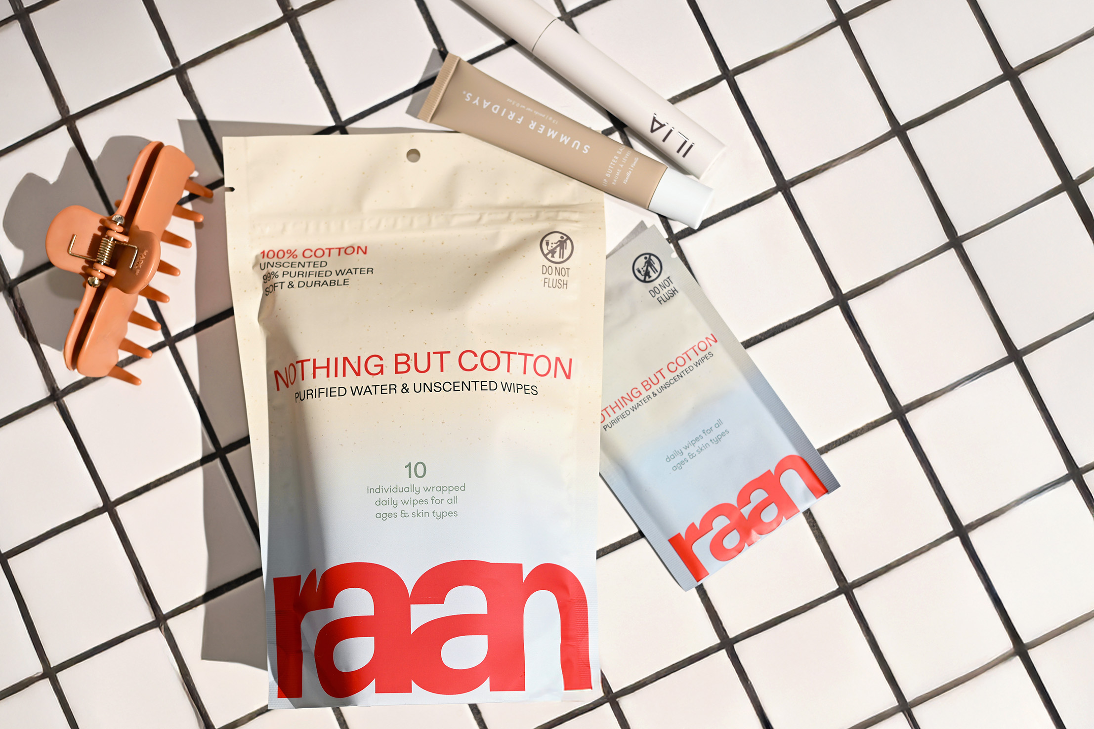 A package of cotton products with a clip and a tube on a grid background.