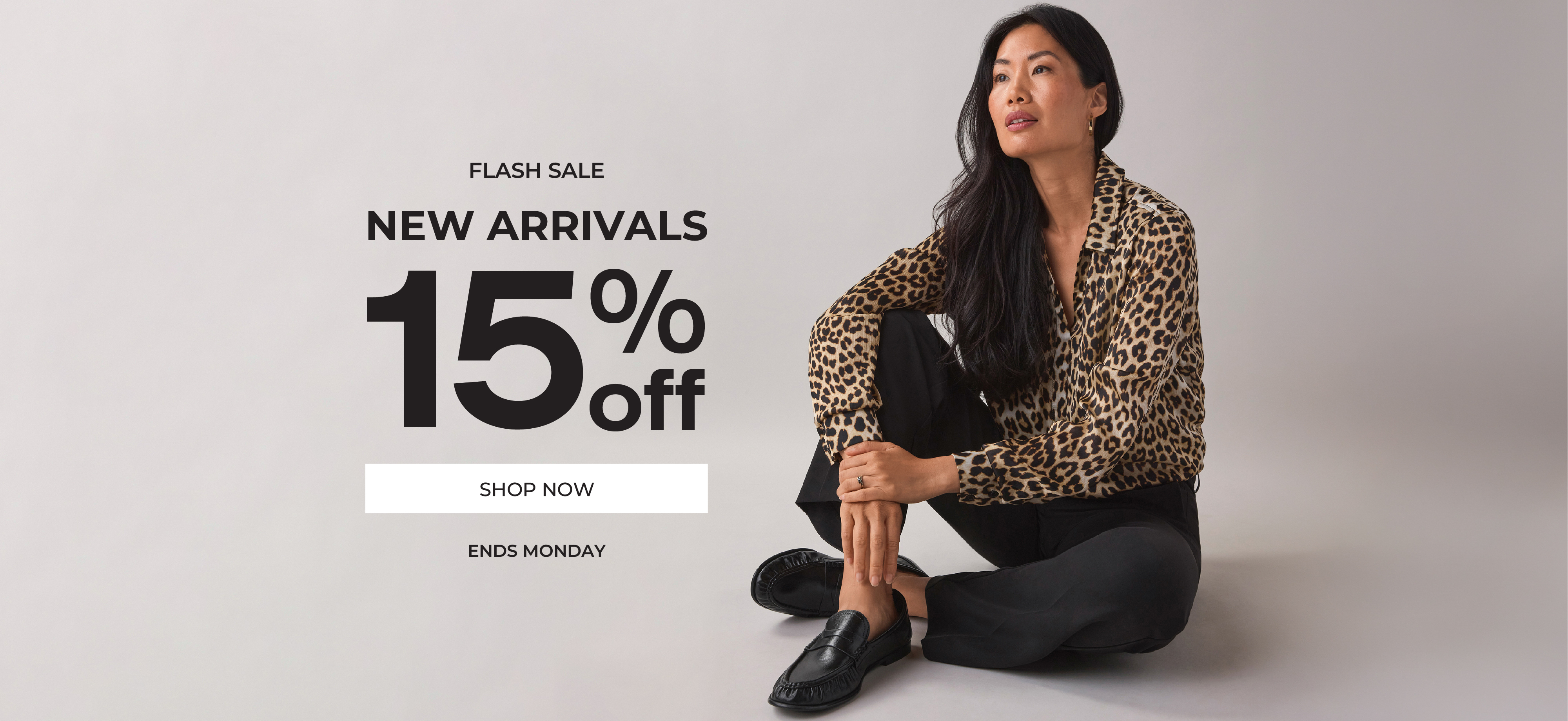 Woman sitting, promoting new arrivals with 15% off discount.