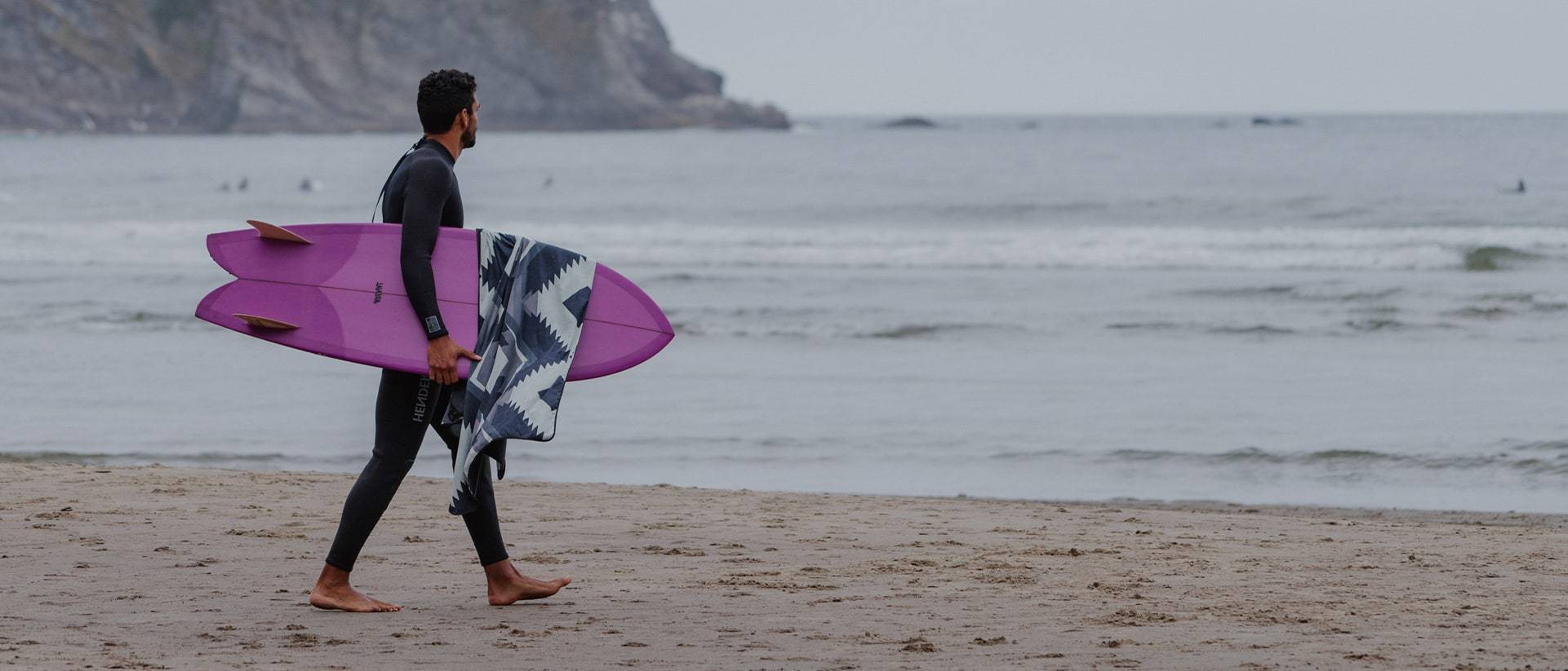 Man surfing with shammy towel draped over his board