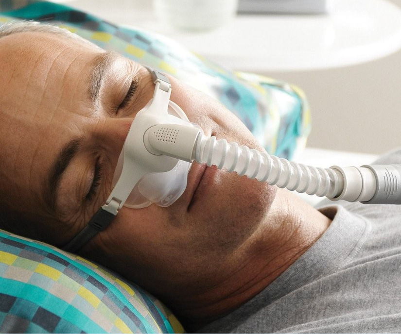 Man sleeping with a CPAP mask on his face.