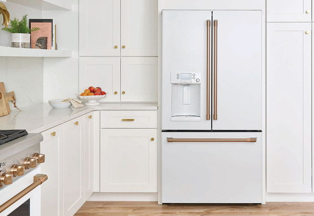Modern kitchen with a white refrigerator and wooden countertop.