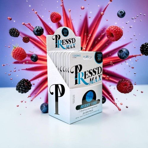 Box of Pressd Max with colorful fruit explosion in background.