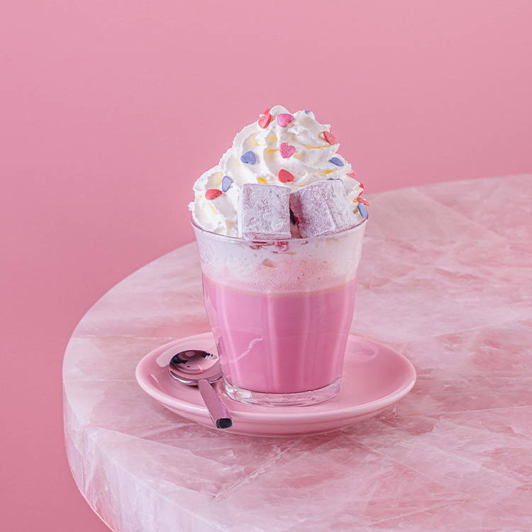 Turkish delight hot chocolate with whipped cream on pink table 