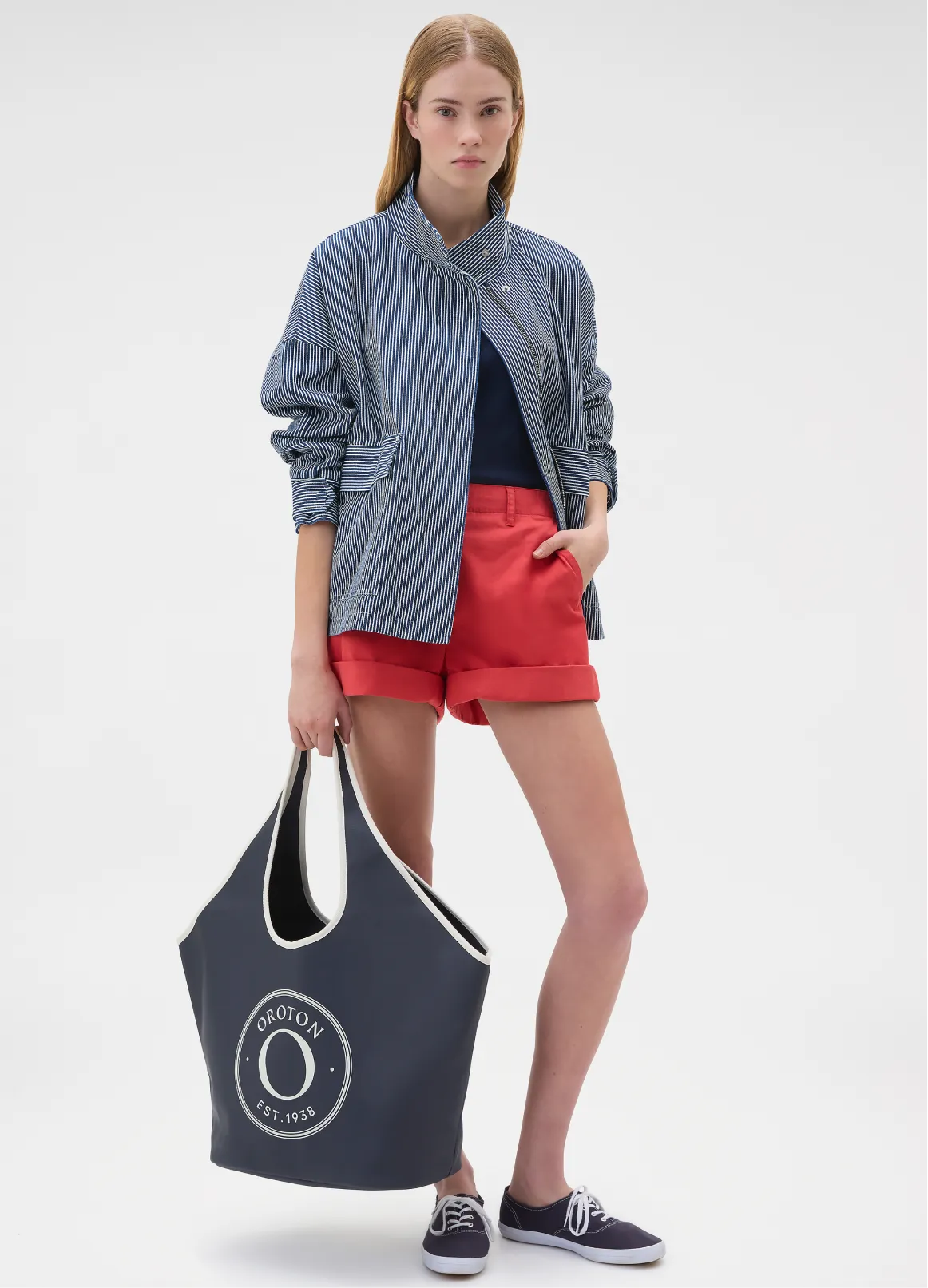Model in casual outfit holding a large tote bag.
