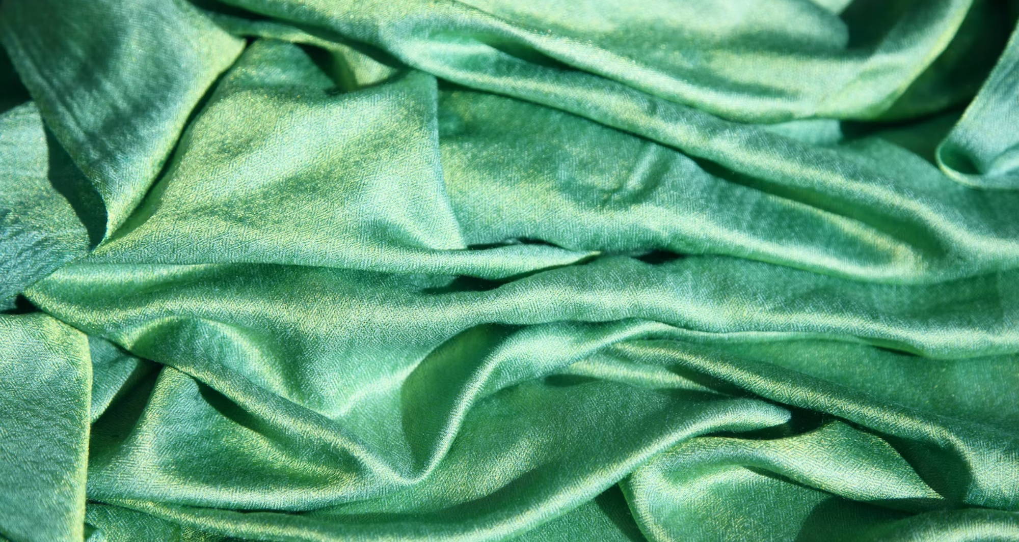 slightly bunched up green silky fabric 