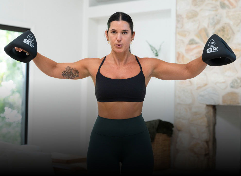 Woman exercising with YBells in a home gym setting.