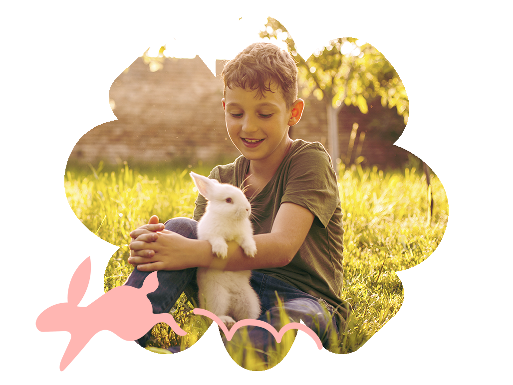 A young boy holding a white bunny- Babo Botanicals