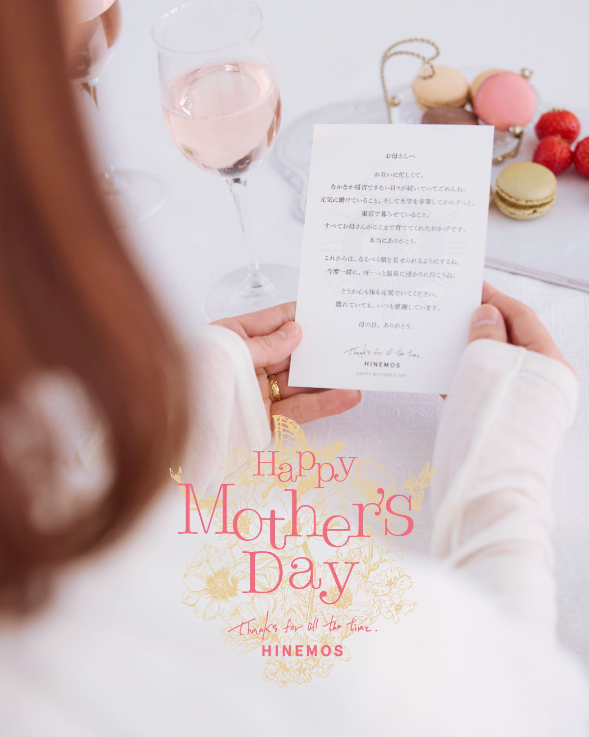 A person holding a Mother's Day card with desserts in the background.