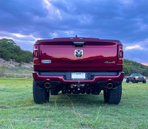 Rear view of a red Dodge Ram 1500 Longhorn showing train horns mounted beneath the bumper