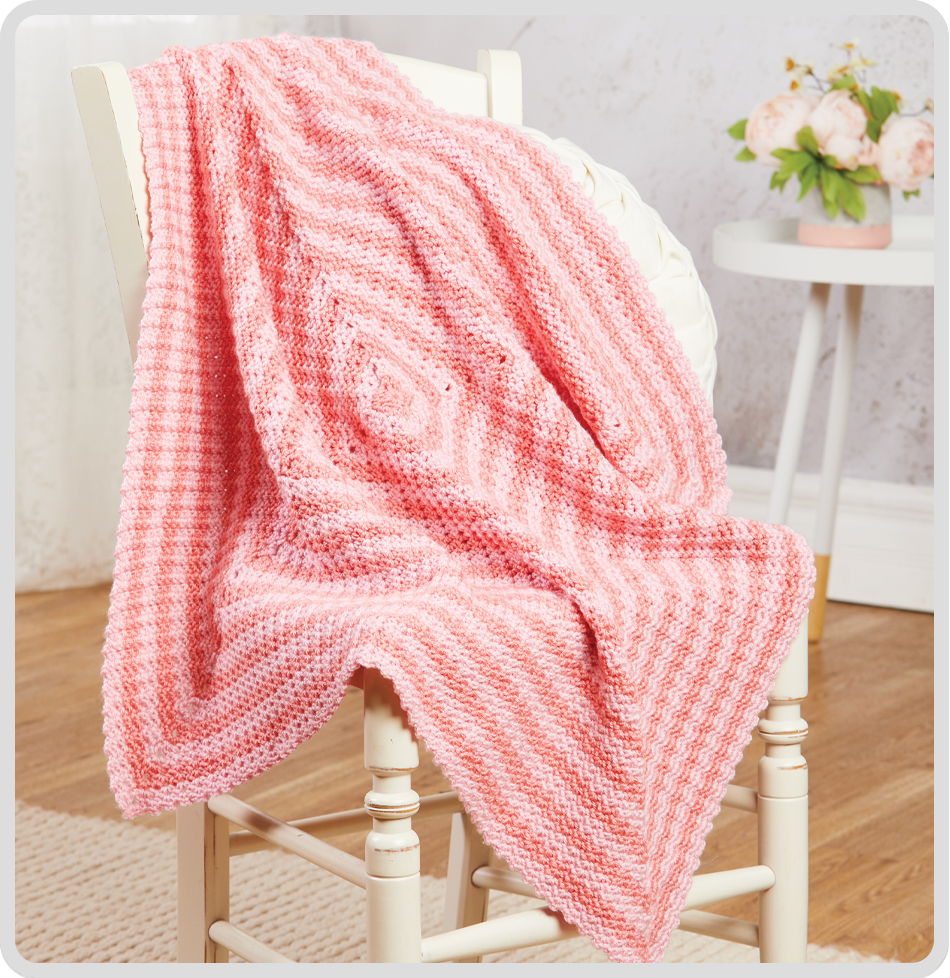 A pink and white striped blanket draped over a chair.