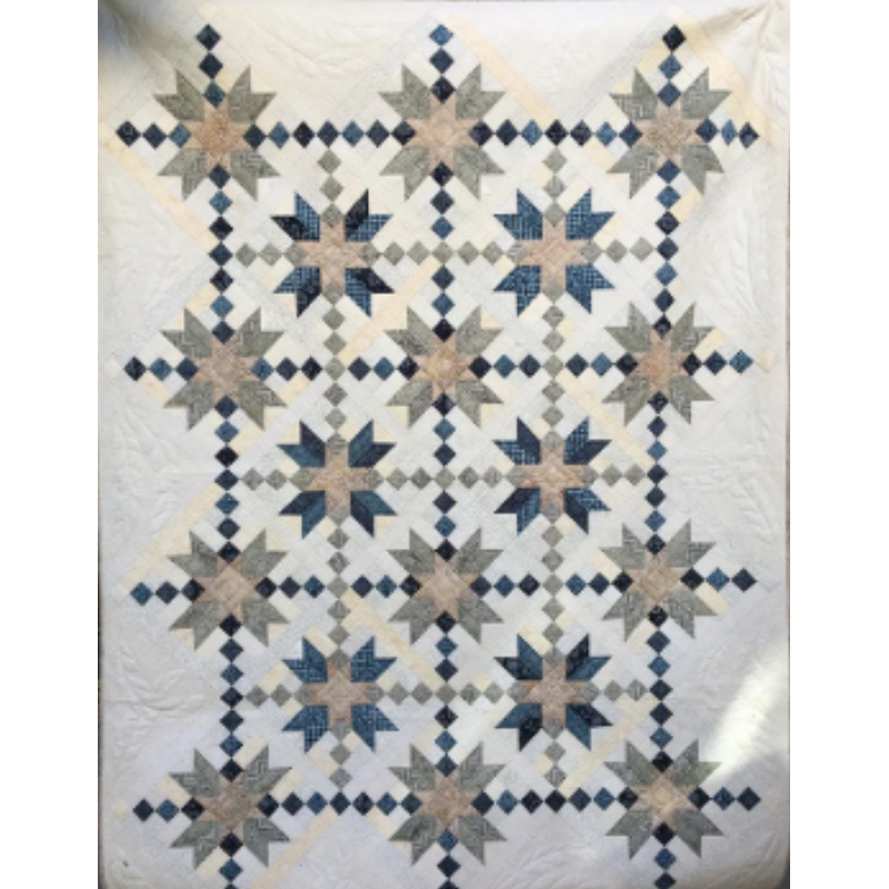 A patterned quilt featuring star motifs in blue and beige colors.