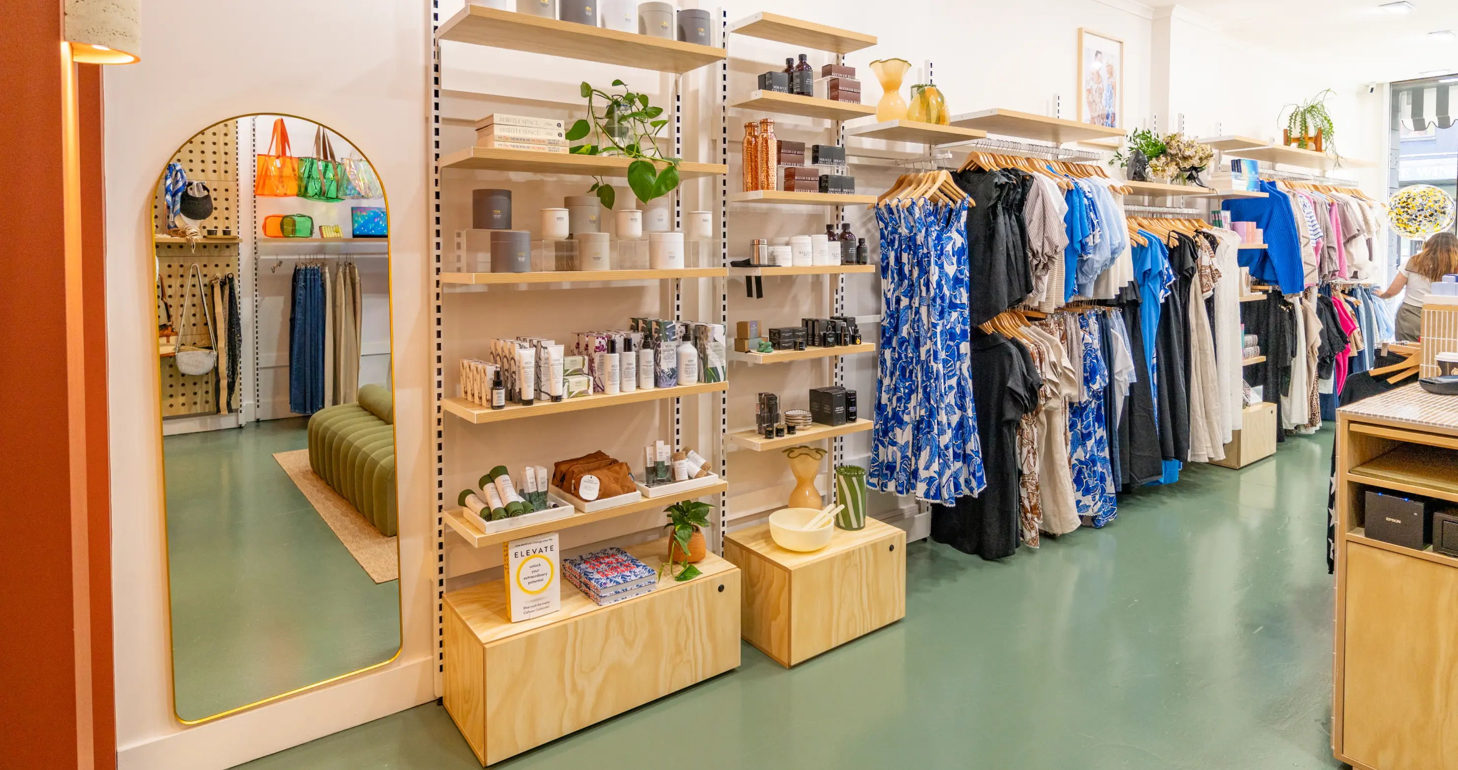 A bright store interior featuring clothing racks and product displays.