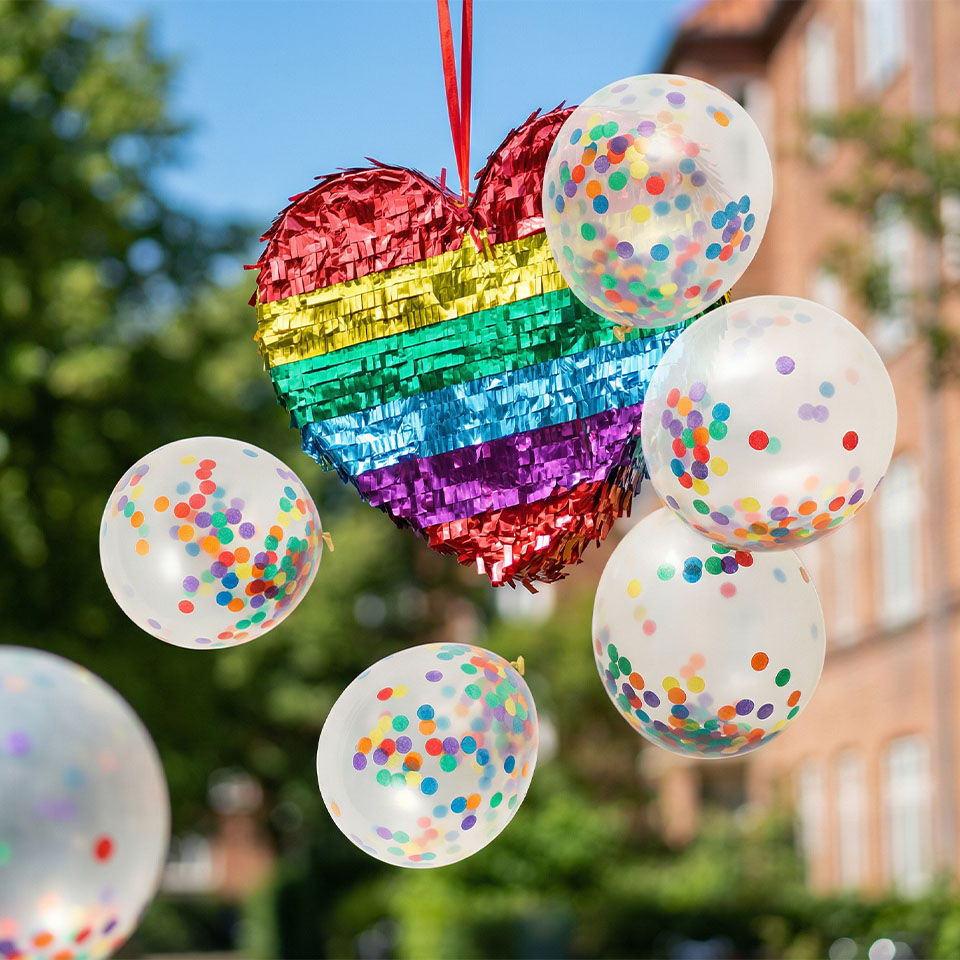 Colorful heart decoration with rainbow stripes and confetti-filled balloons.