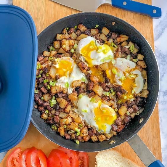 A bird’s eye view of a Misen Nonstick pan filled with an egg, potato, and steak hash.