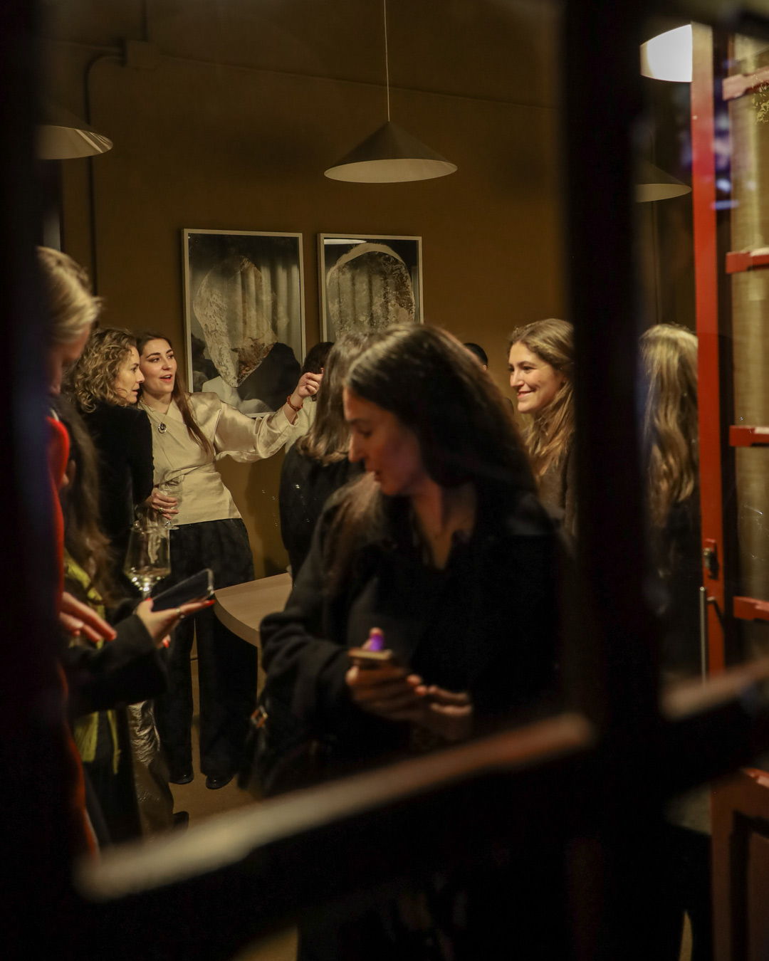 Group of women socializing in a warmly lit indoor space.