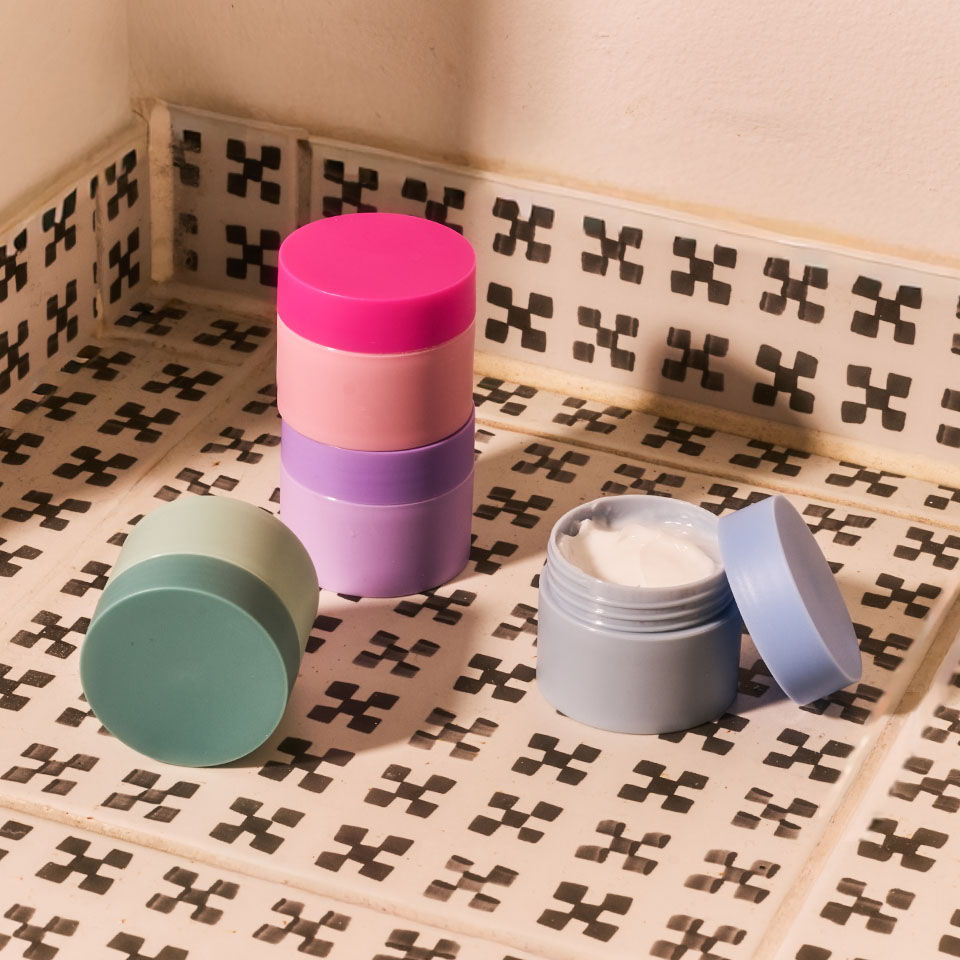 Colorful cosmetic containers on a patterned surface.