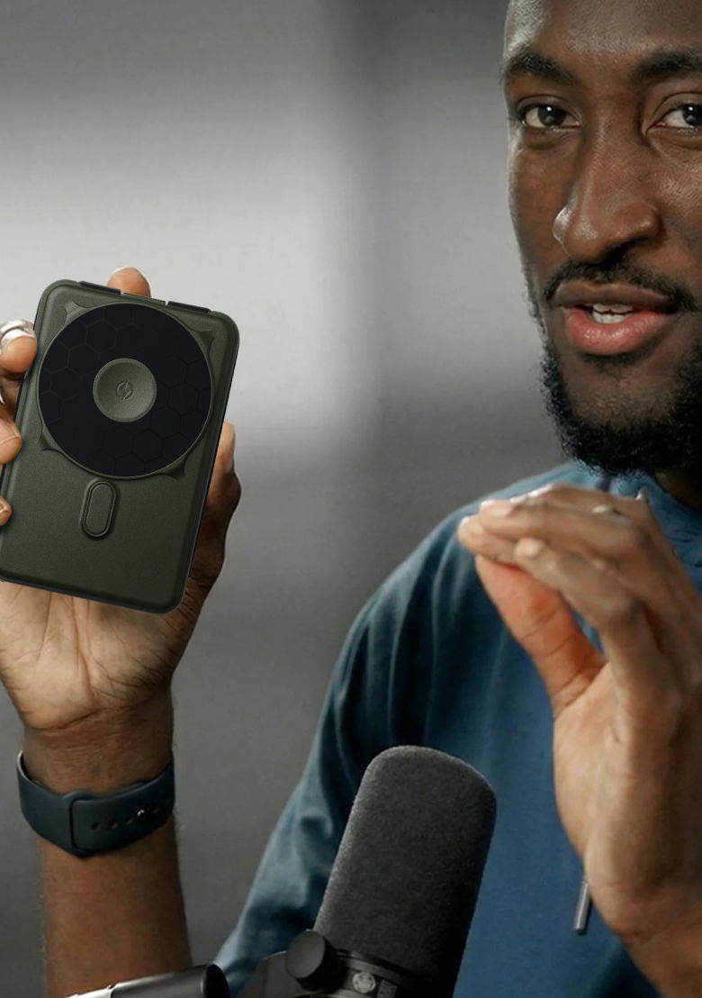 Person holding a smartphone with a circular attachment, speaking enthusiastically.