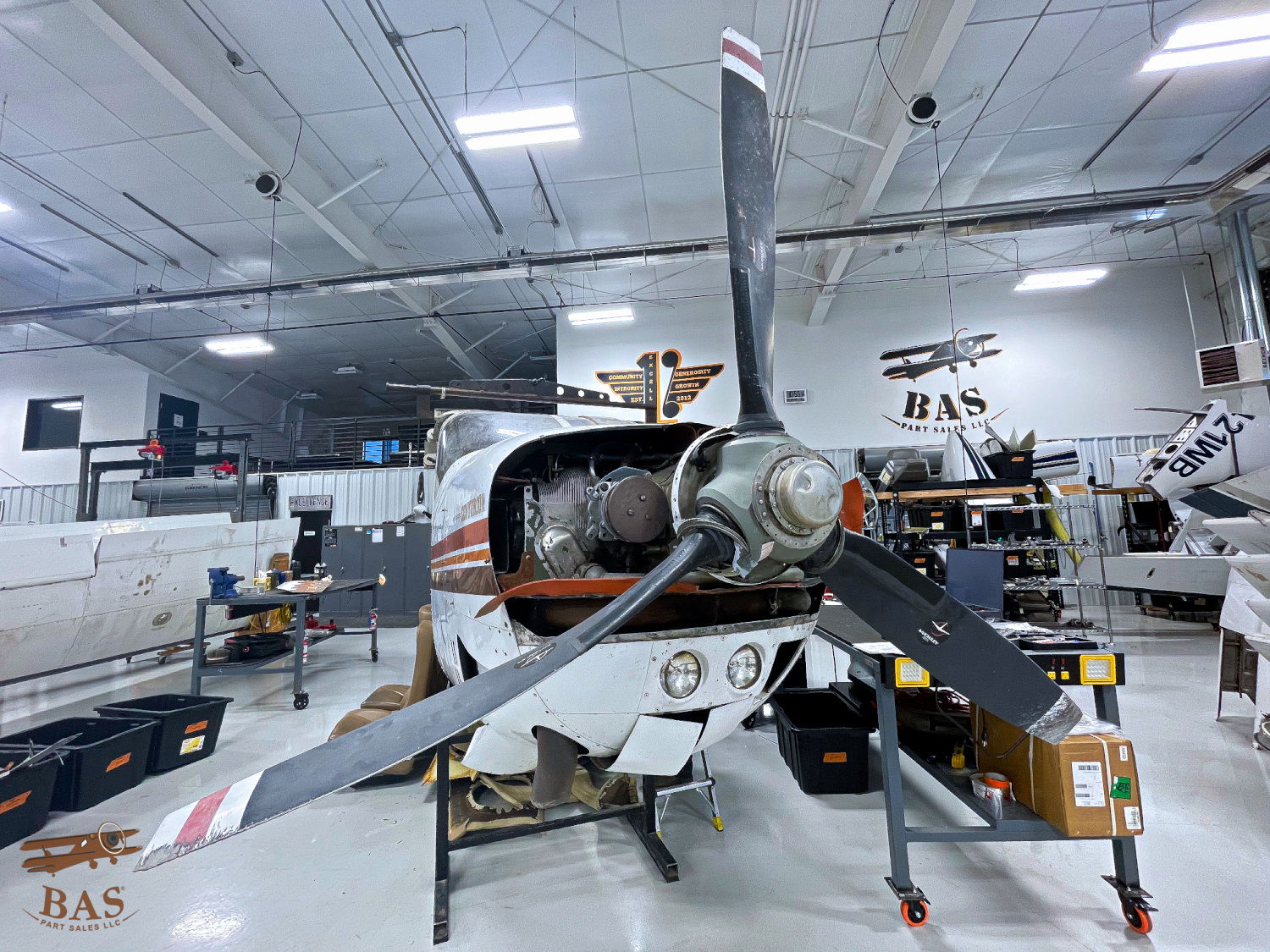 Aircraft in a hangar with visible propeller and engine components.