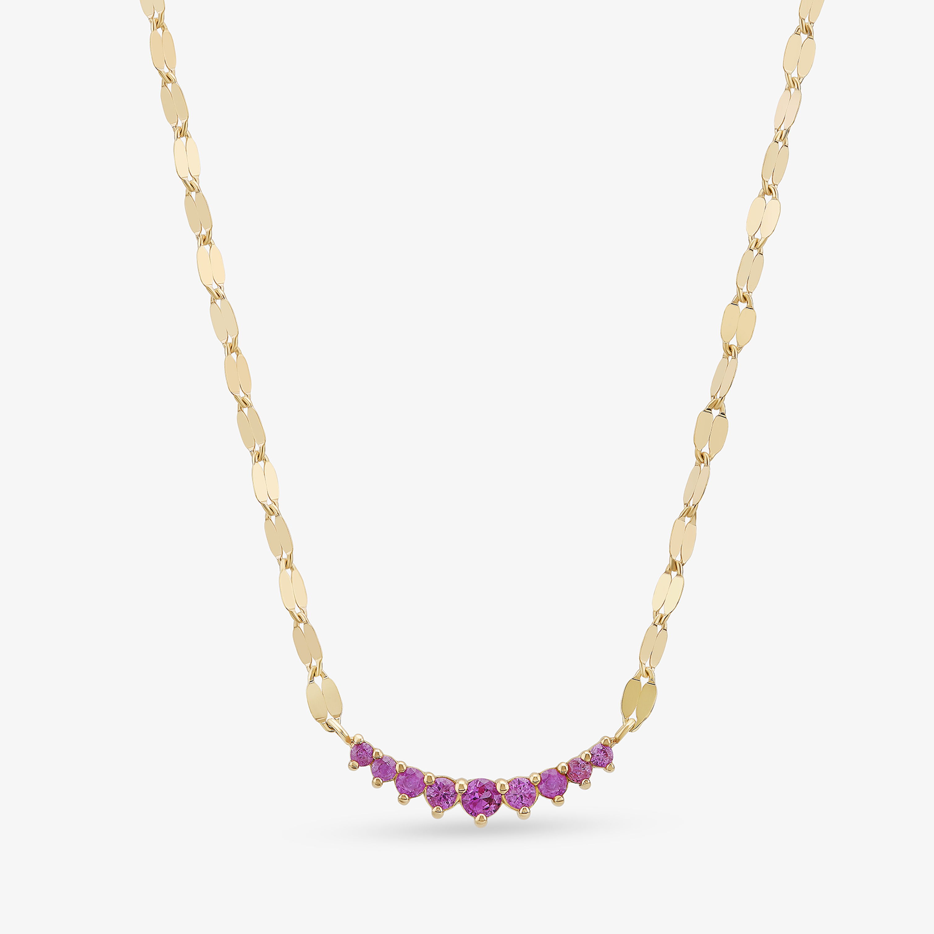 Yellow gold necklace featuring a curved row of vibrant pink gemstones on a delicate chain.