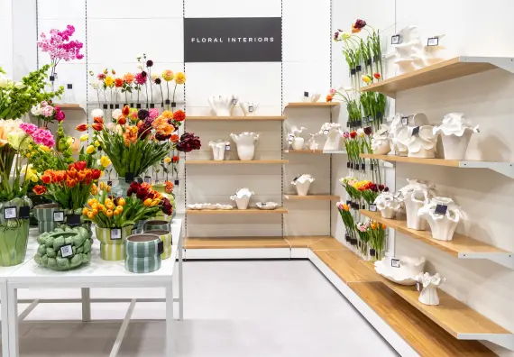 Flower shop display with various floral arrangements and decorative vases.