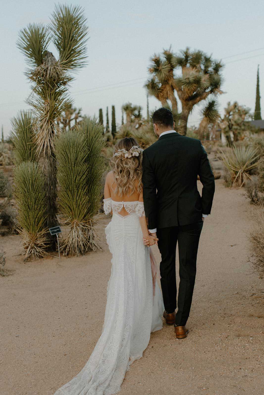 Braut und Bräutigam zwischen Bäumen in Joshua Tree