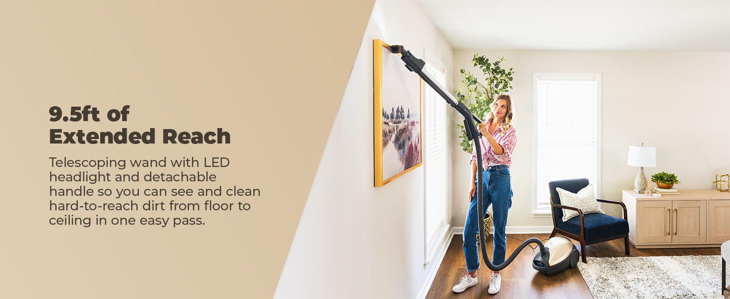 A person using a vacuum cleaner with extended reach in a living room.