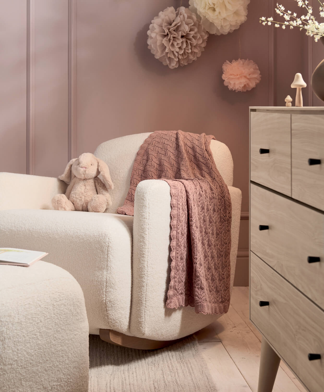 Cozy living room corner with a plush chair, blanket, and decorative accents.