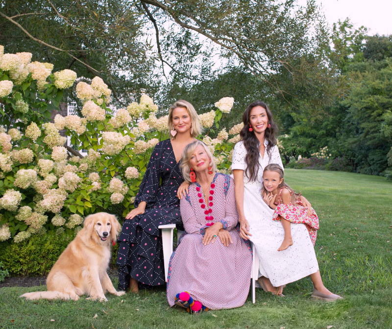 Sylvie Chantecaille and her family sitting in her backyard with her dogs