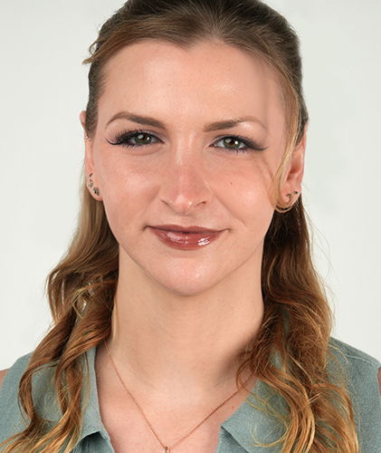 A woman with long hair smiles at the camera.