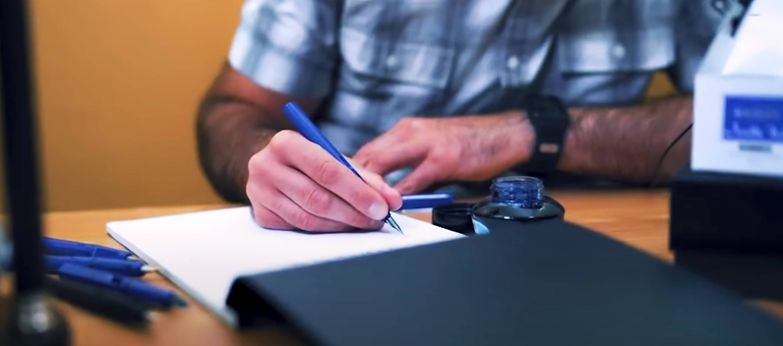 A close up shot of a person learning how to write with a fountain pen