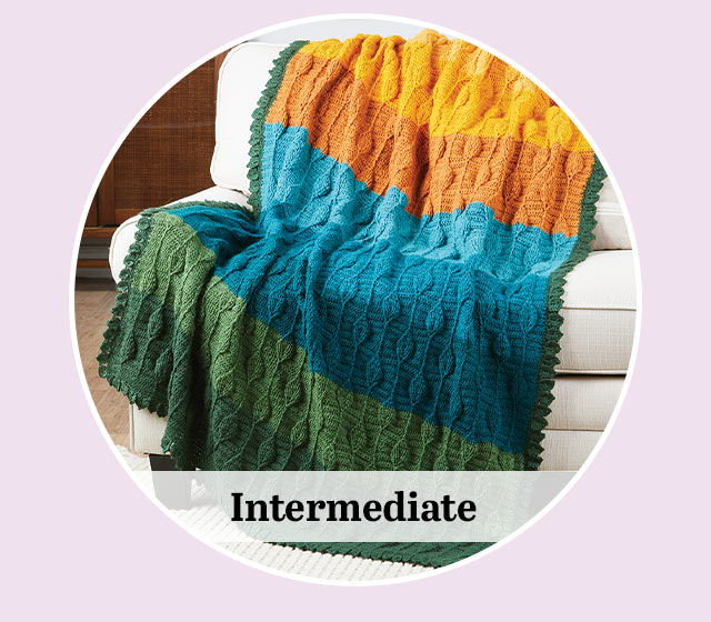 Colorful knitted blanket displayed on a couch with 