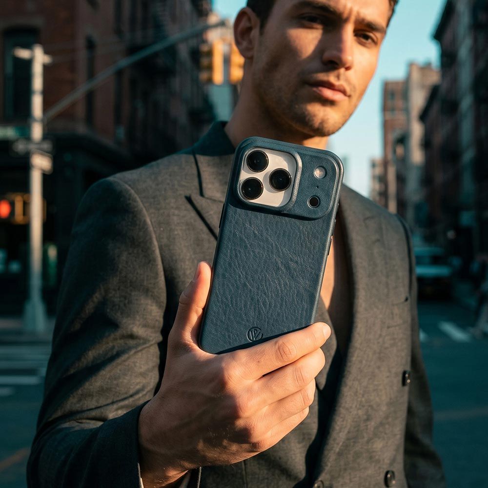 Ein Mann hält eine blaue iPhone 17 Pro Hülle von Good Wilhelm aus Leder in der Hand
