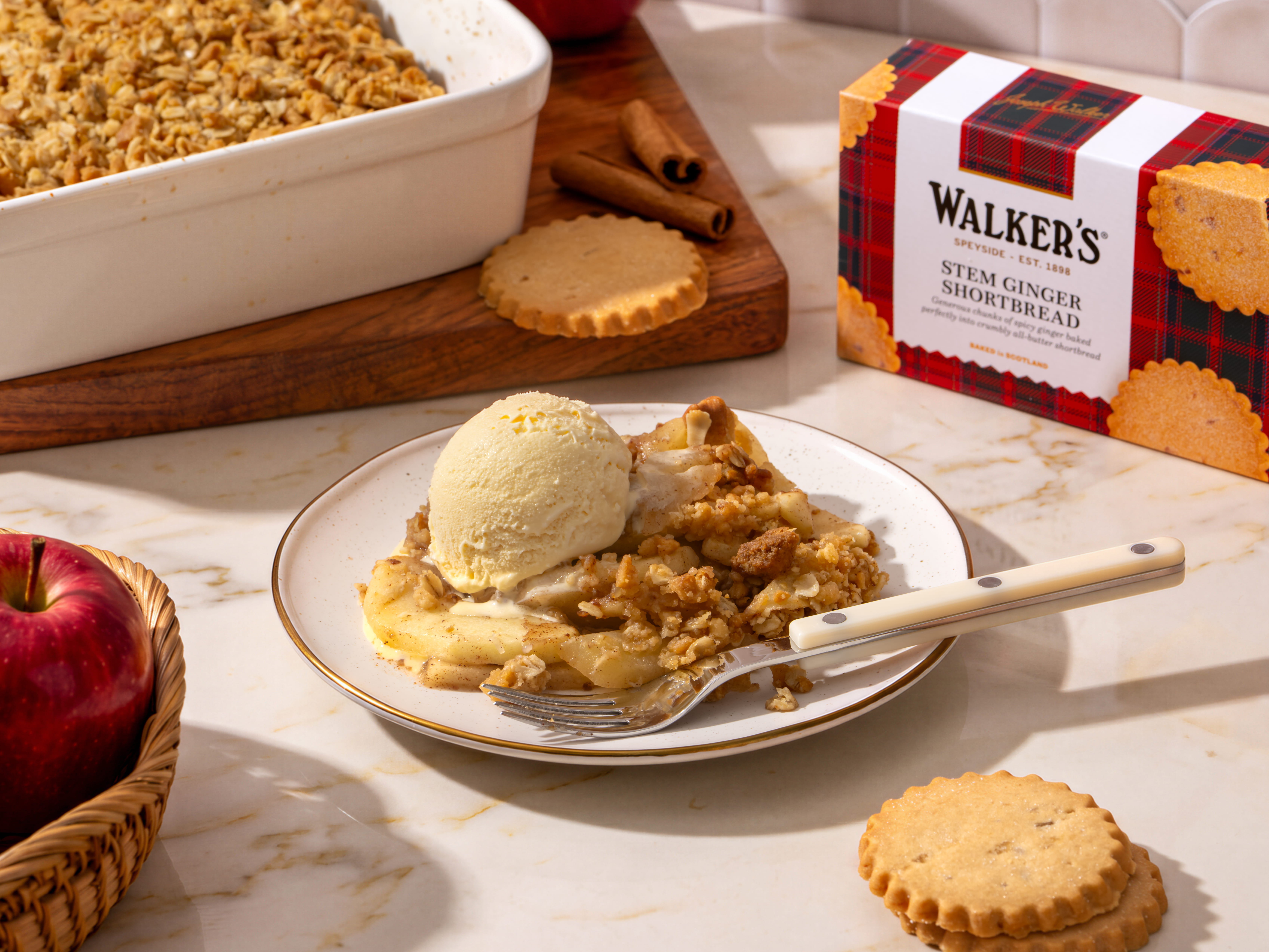 Plate of apple crumble with ice cream and cookies beside it.