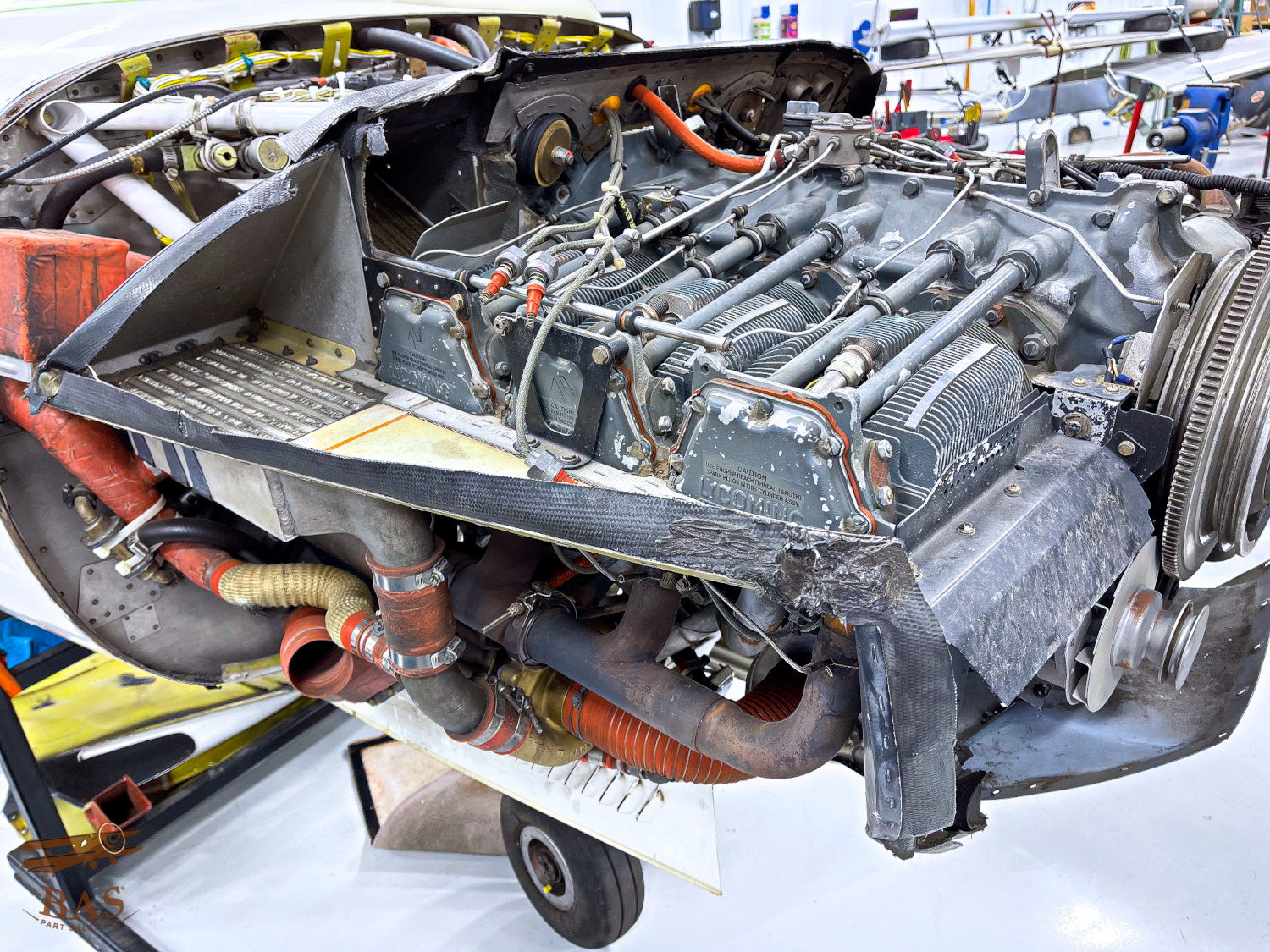 Aircraft engine displayed on a cart in a workshop setting.