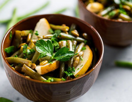 Bowl of green beans with lemon and herbs.