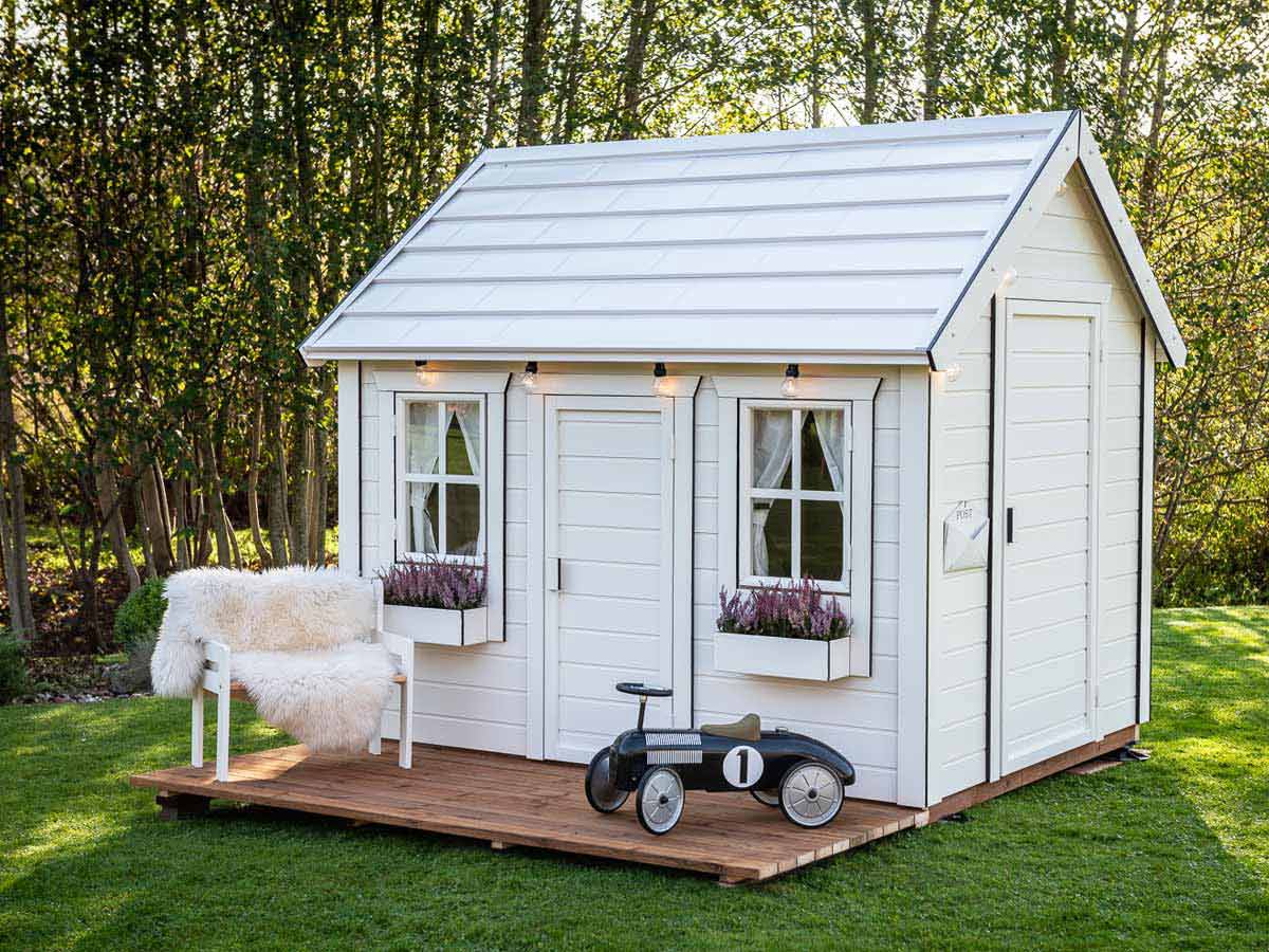 Black and white outdoor playhouse with white walls with black trims and wooden terrace by WholeWoodPlayhouses