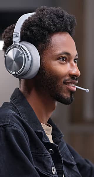 Person wearing gaming headphones, smiling, with a microphone and a toothpick in mouth.