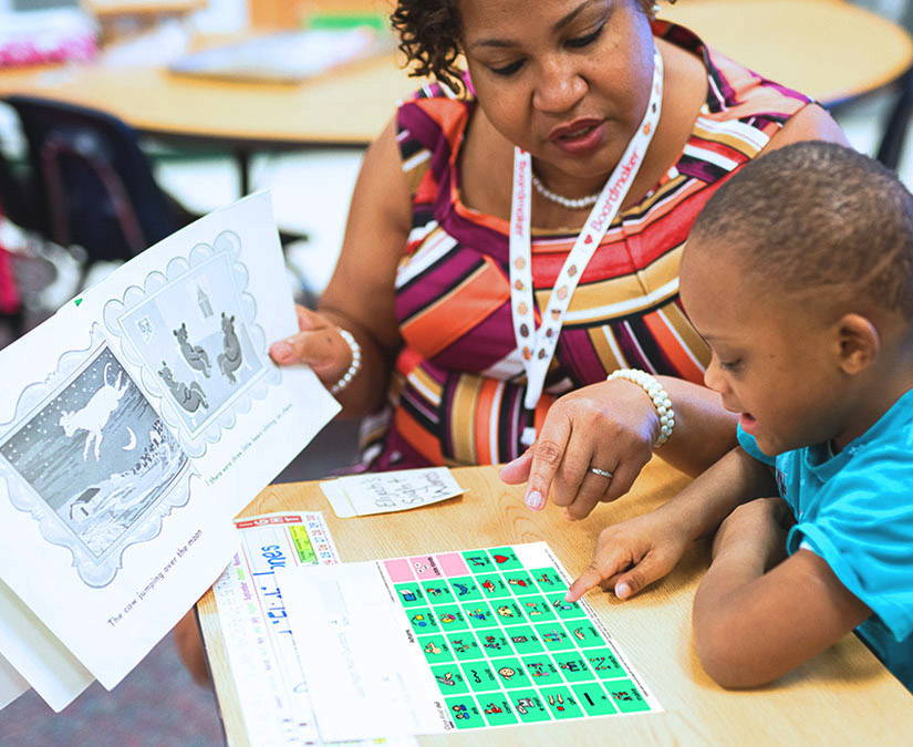 Teacher using Tobii Dynavox Core First Communication Board with a student.