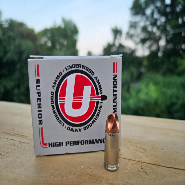 A bullet next to a branded ammunition box outdoors.