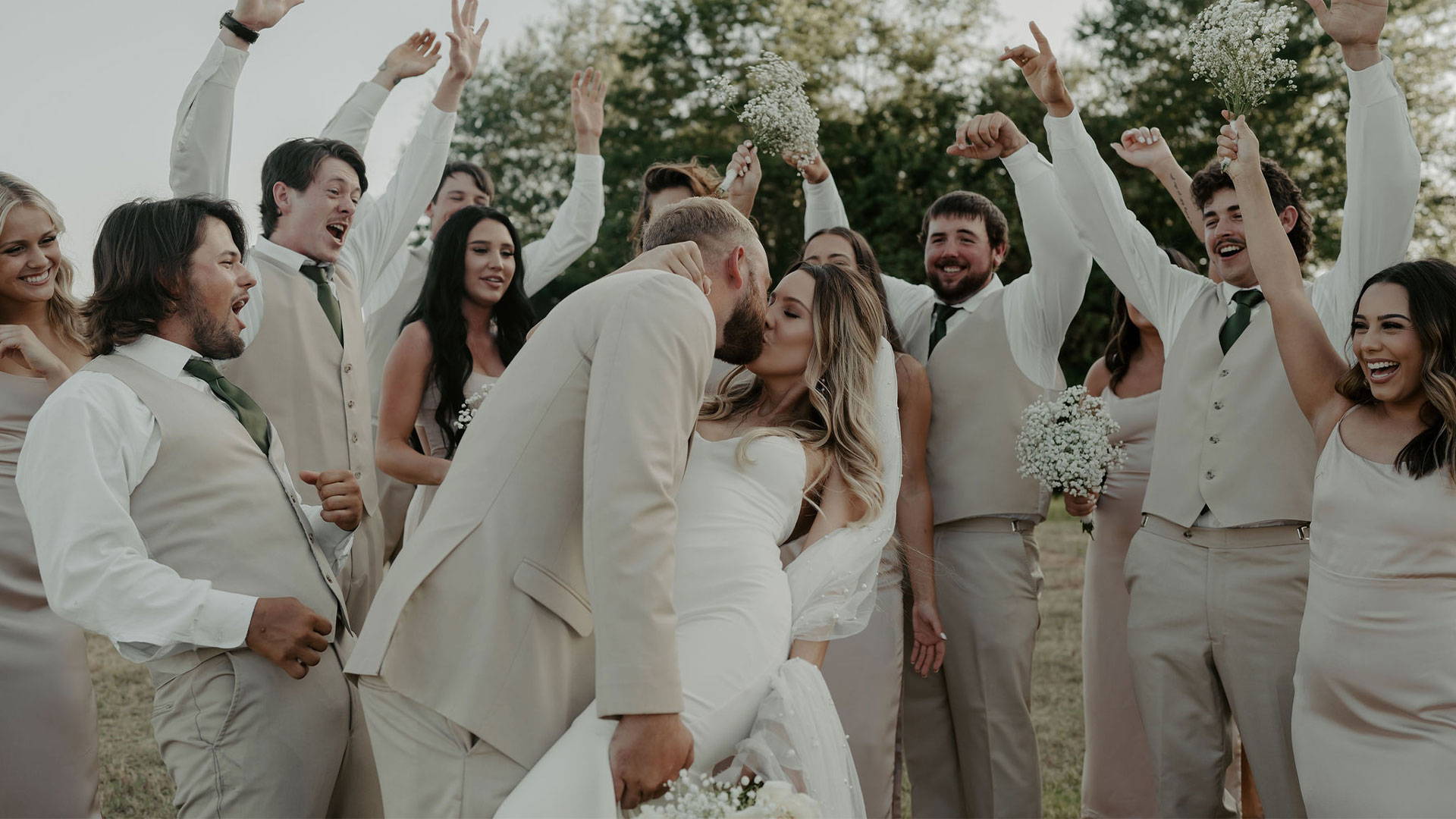 Novios compartiendo un beso entre el grupo nupcial